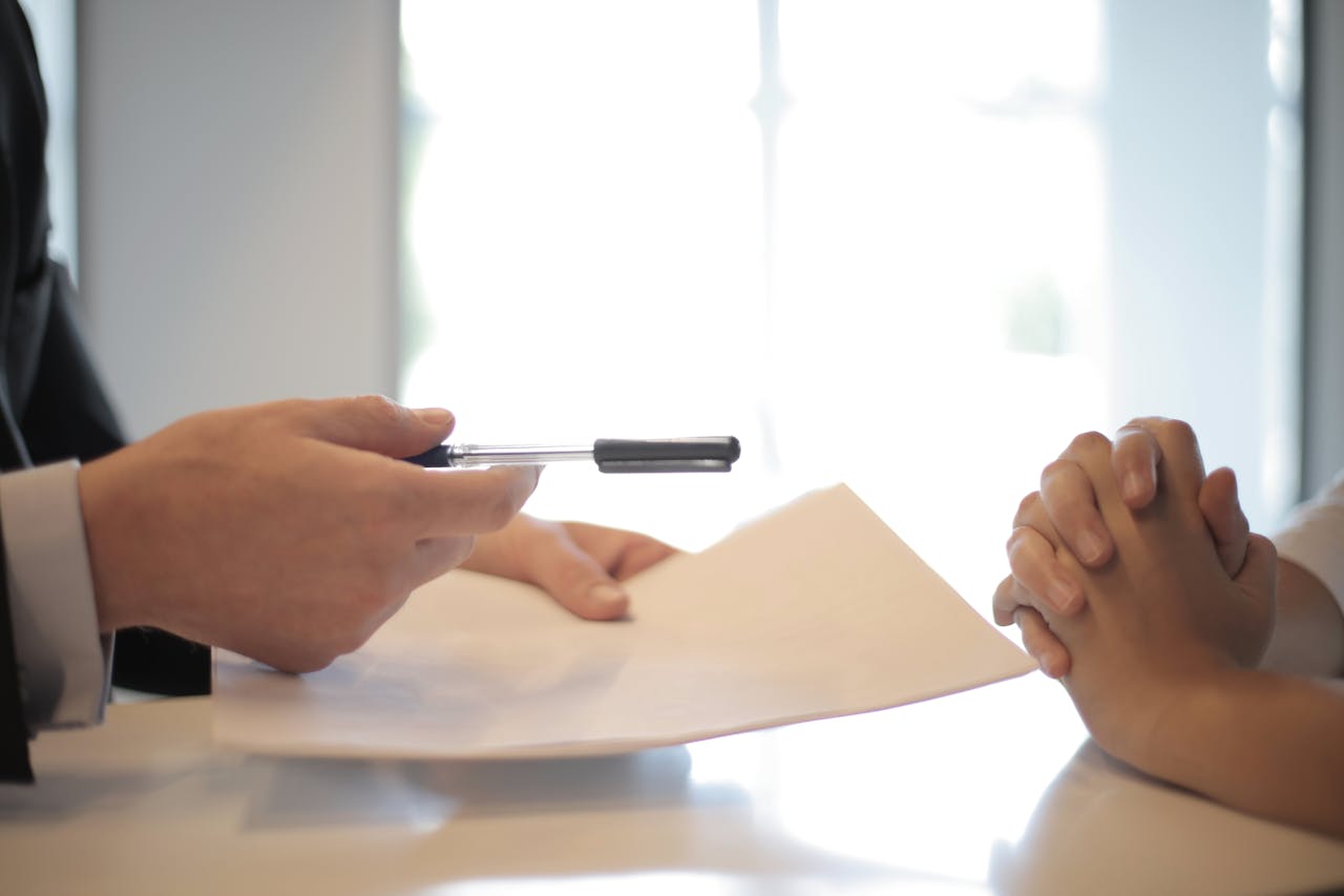 services-06 Close-up of a contract signing with hands over documents. Professional business interaction.